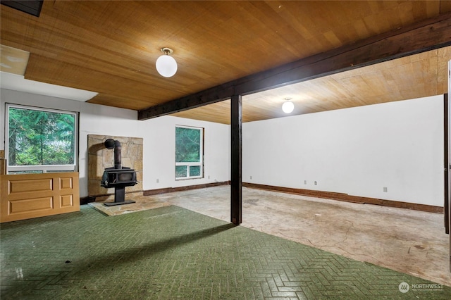 basement with wood ceiling and a wood stove