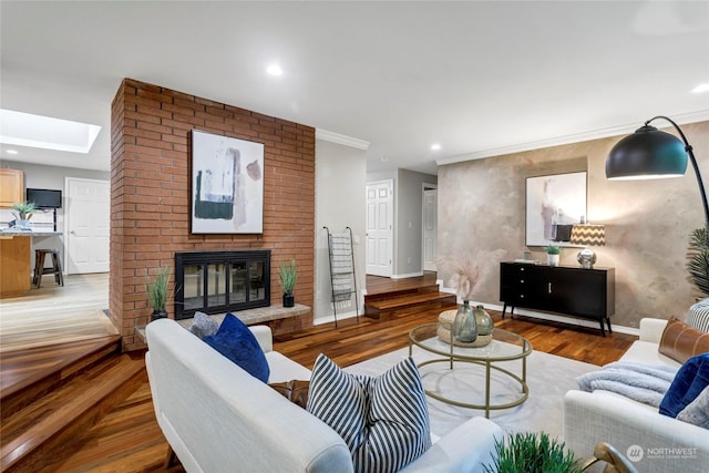 living room featuring hardwood / wood-style floors, a fireplace, and a skylight