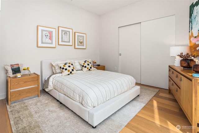 bedroom with a closet and light hardwood / wood-style flooring