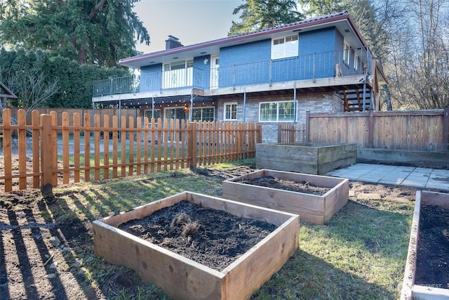 rear view of property with a balcony and a lawn