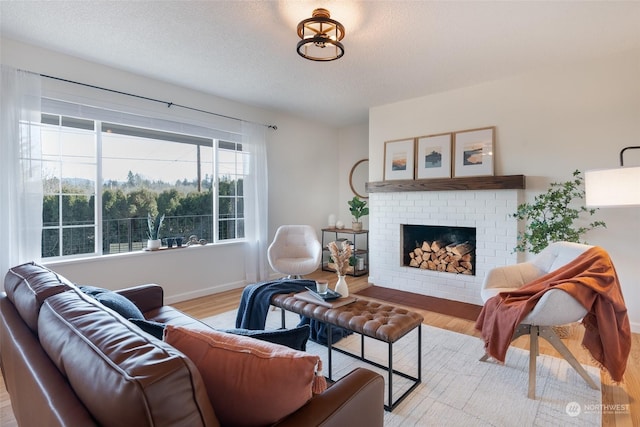 living room featuring a fireplace, a textured ceiling, and light wood-type flooring