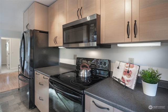 kitchen with light brown cabinetry and black appliances