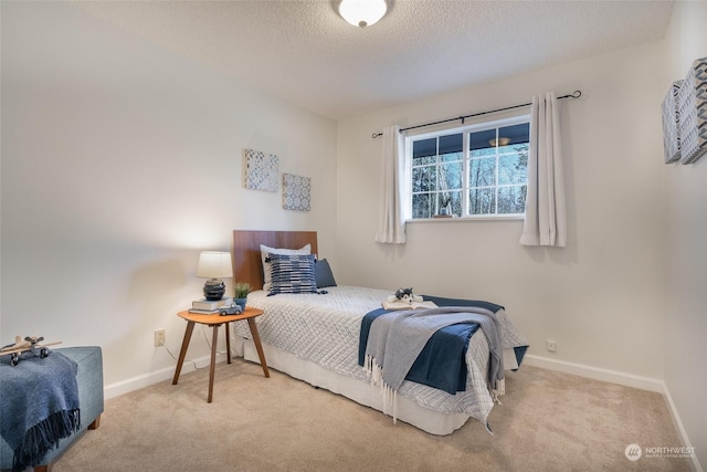 bedroom featuring light carpet and a textured ceiling