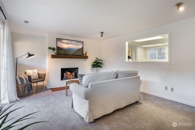 carpeted living room featuring a textured ceiling and a fireplace