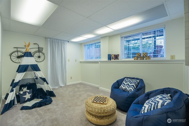 sitting room with a drop ceiling and carpet floors