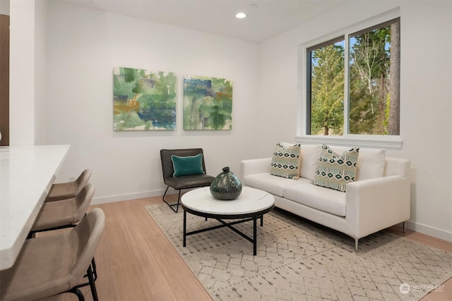 living room with recessed lighting, light wood-style flooring, and baseboards