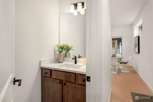 bathroom with vanity, baseboards, and wood finished floors