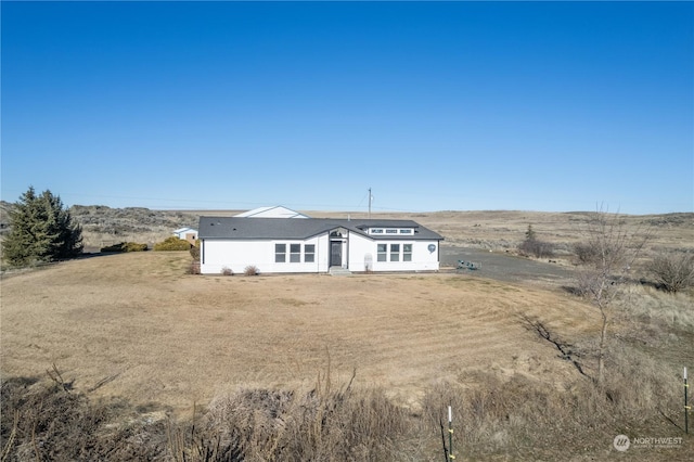 view of front of home with a front yard and a rural view