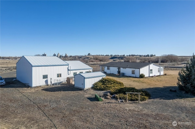 back of property featuring an outdoor structure