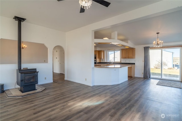 kitchen featuring hardwood / wood-style flooring, a wealth of natural light, kitchen peninsula, and a wood stove