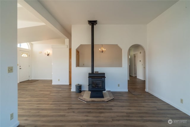 unfurnished living room featuring a wood stove and dark wood-type flooring