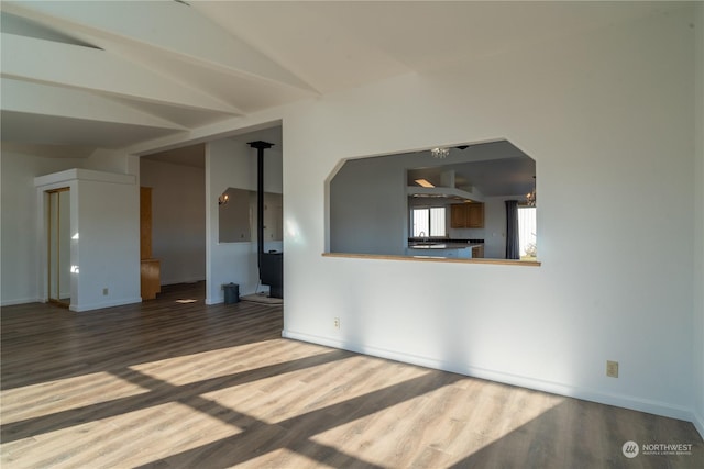 unfurnished living room featuring wood-type flooring and vaulted ceiling