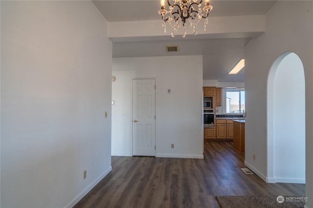 interior space featuring an inviting chandelier and dark hardwood / wood-style floors