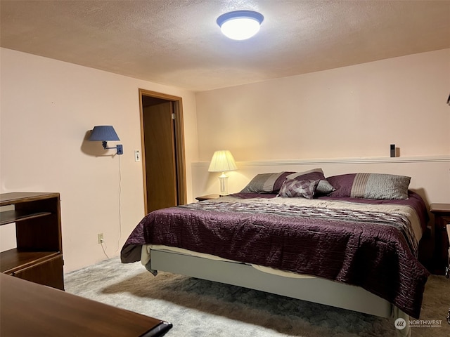 bedroom with carpet floors and a textured ceiling