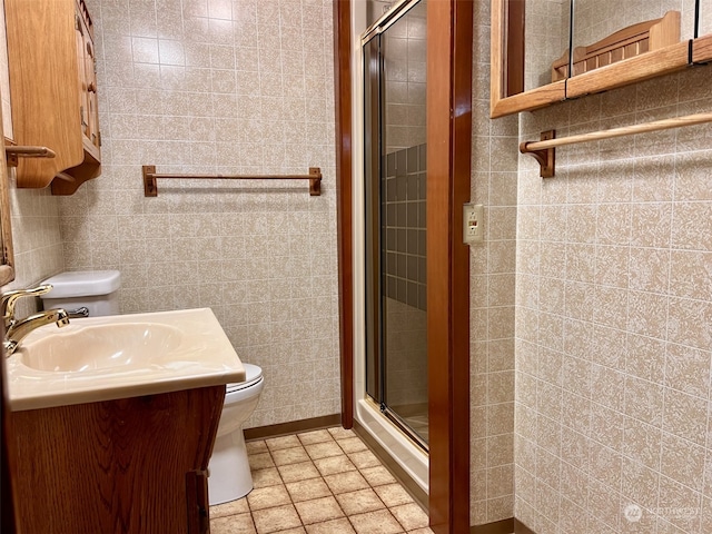 bathroom featuring vanity, toilet, tile walls, and walk in shower