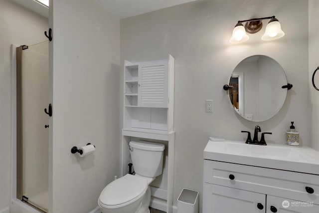 bathroom featuring vanity, a shower with shower door, and toilet