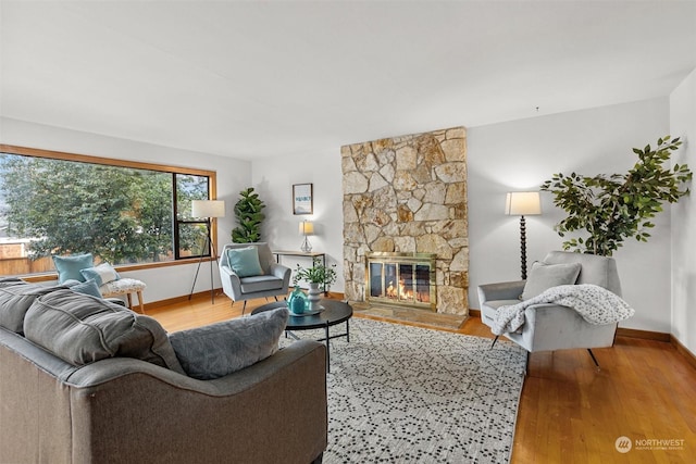 living room with a stone fireplace and light hardwood / wood-style floors