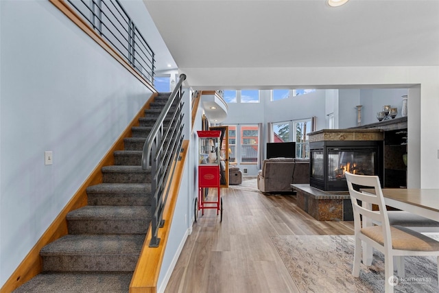 stairs with hardwood / wood-style floors and a fireplace