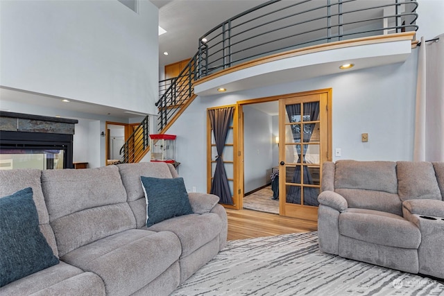 living room with a towering ceiling and light wood-type flooring