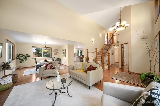 living room featuring an inviting chandelier, high vaulted ceiling, and light wood-type flooring