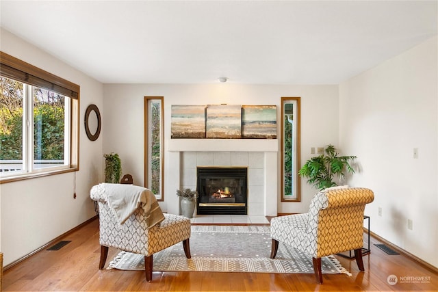 sitting room with a fireplace and light hardwood / wood-style floors