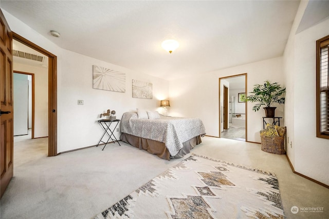 carpeted bedroom featuring ensuite bath