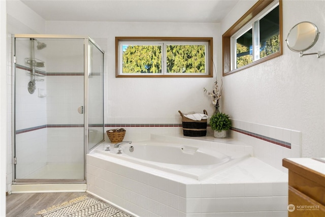 bathroom with shower with separate bathtub, a healthy amount of sunlight, and hardwood / wood-style floors