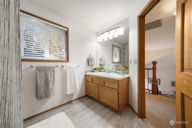 bathroom featuring vanity, wood-type flooring, and a textured ceiling