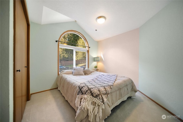 bedroom with lofted ceiling and light carpet