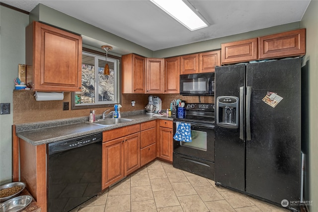 kitchen with dark countertops, brown cabinets, a sink, and black appliances