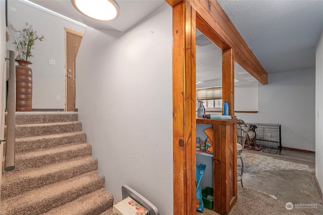 stairway with a textured ceiling