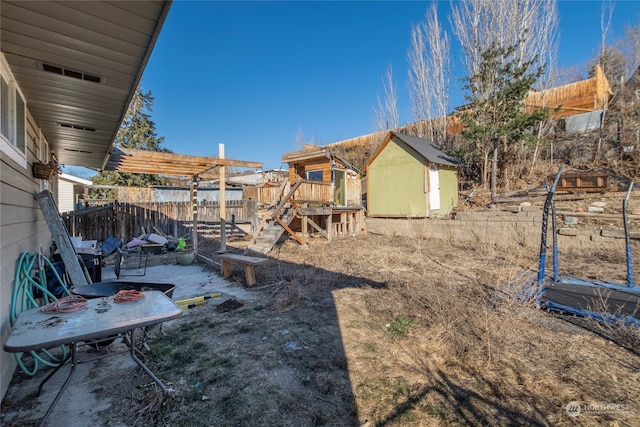 view of yard featuring a patio area, a fenced backyard, an outdoor structure, and a storage shed