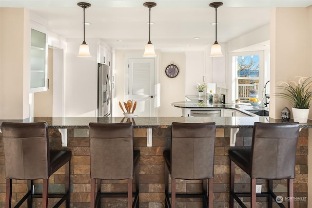 bar with appliances with stainless steel finishes, pendant lighting, and a sink