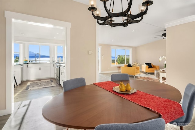 dining space with ceiling fan with notable chandelier, recessed lighting, and light wood-style floors