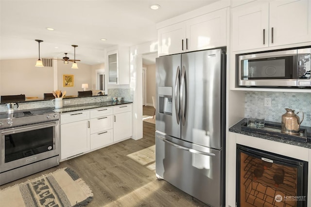 kitchen with wine cooler, stainless steel appliances, decorative backsplash, white cabinets, and wood finished floors