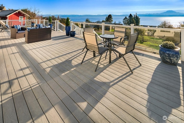 wooden deck with outdoor dining area, outdoor lounge area, and a water and mountain view