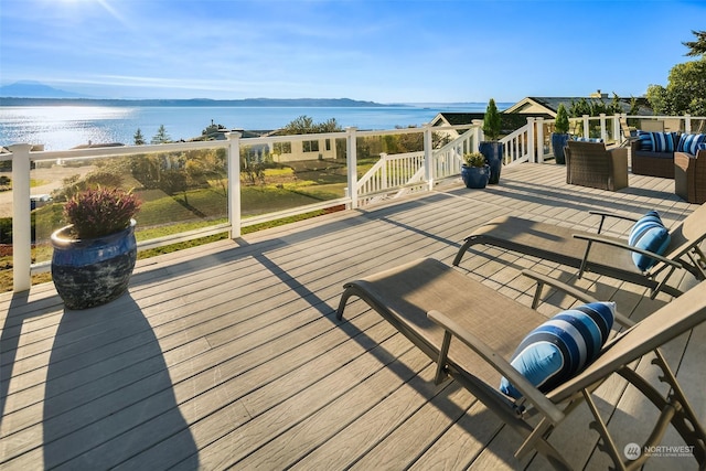 wooden deck featuring a water view and an outdoor living space