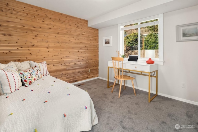 bedroom featuring carpet floors, wooden walls, and baseboards