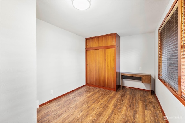 unfurnished bedroom with dark hardwood / wood-style flooring