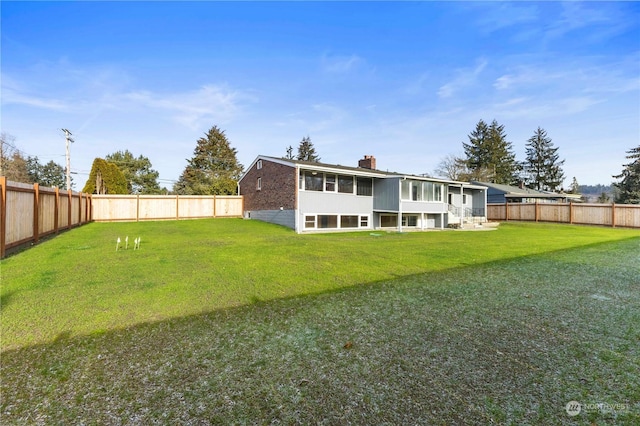 rear view of property with a yard and a sunroom