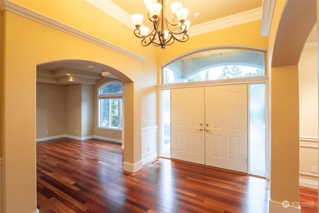 foyer featuring crown molding, dark hardwood / wood-style floors, a wealth of natural light, and a notable chandelier