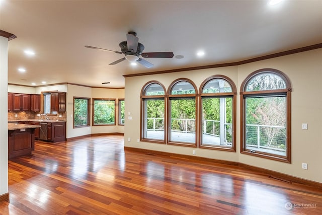 unfurnished living room with ornamental molding, sink, and dark hardwood / wood-style floors