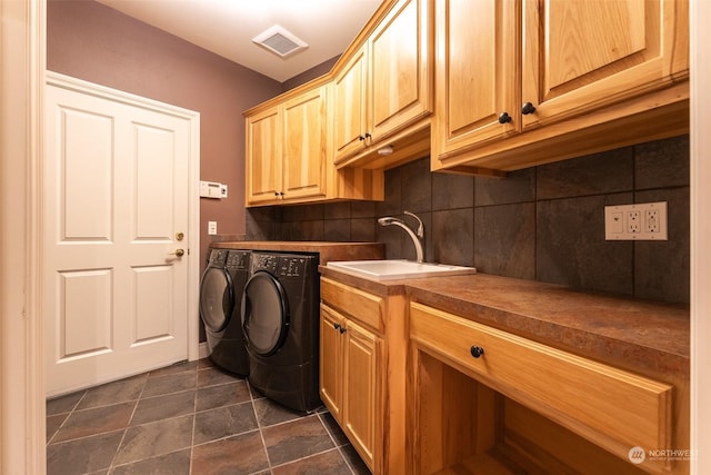 washroom with sink, washer and clothes dryer, and cabinets