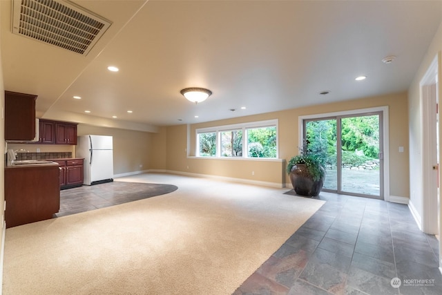 unfurnished living room with sink and dark colored carpet