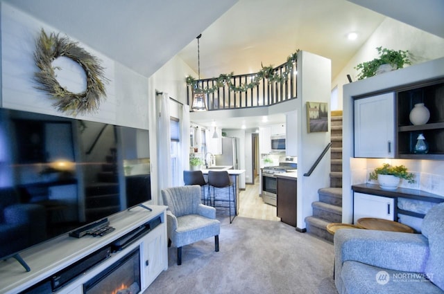 living room with sink, light colored carpet, and high vaulted ceiling