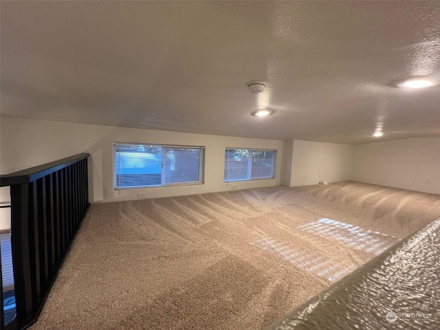 bonus room featuring a textured ceiling and carpet flooring