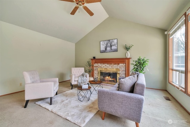 living room with ceiling fan, a fireplace, high vaulted ceiling, and light carpet