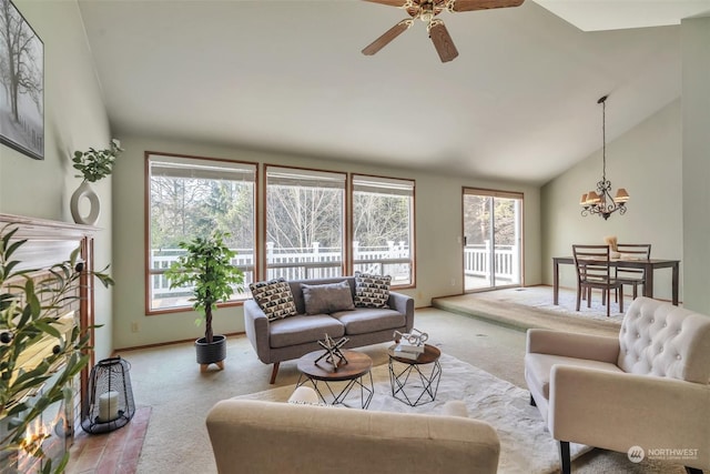 carpeted living room featuring ceiling fan with notable chandelier and vaulted ceiling