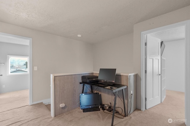 carpeted office space featuring a textured ceiling