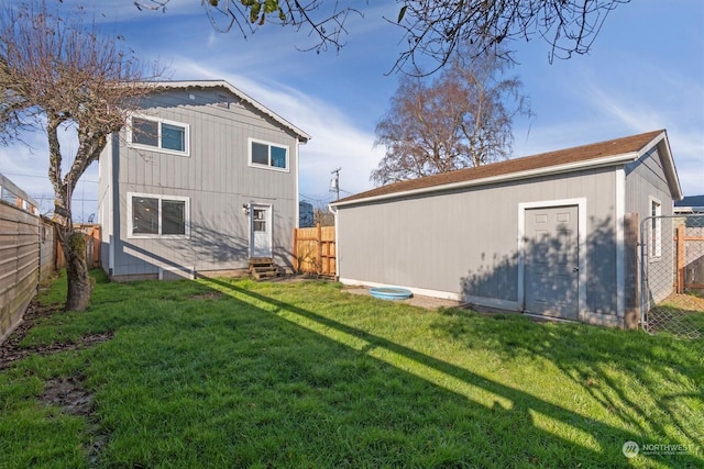 rear view of property with an outbuilding and a lawn